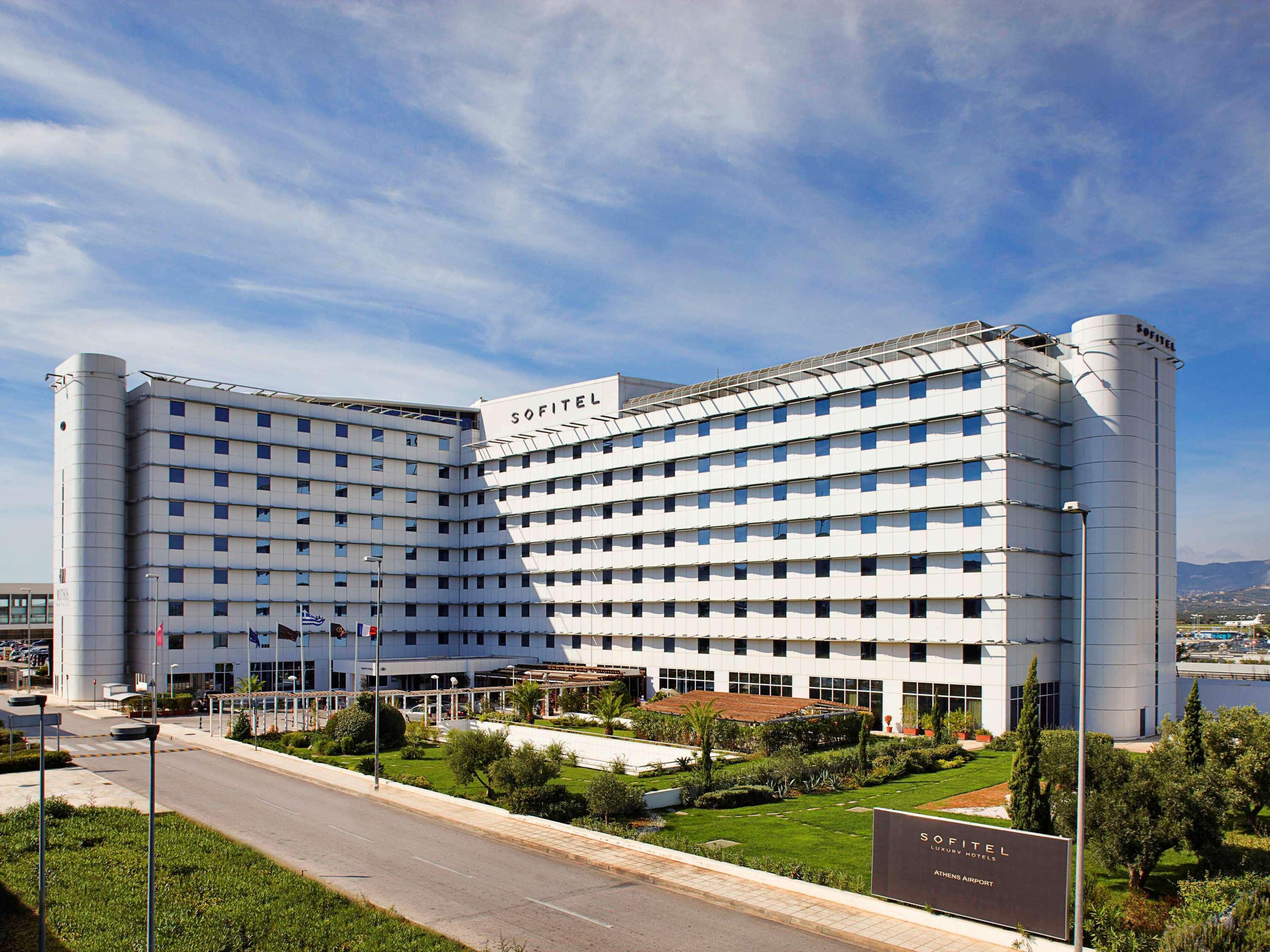 Sofitel Athens Airport Hotel Spata  Luaran gambar The photo shows a modern hotel building with a distinct architectural design. It is a multi-story structure featuring a combination of glass and concrete elements, characterized by a large facade that has a series of windows. The hotel appears to be 